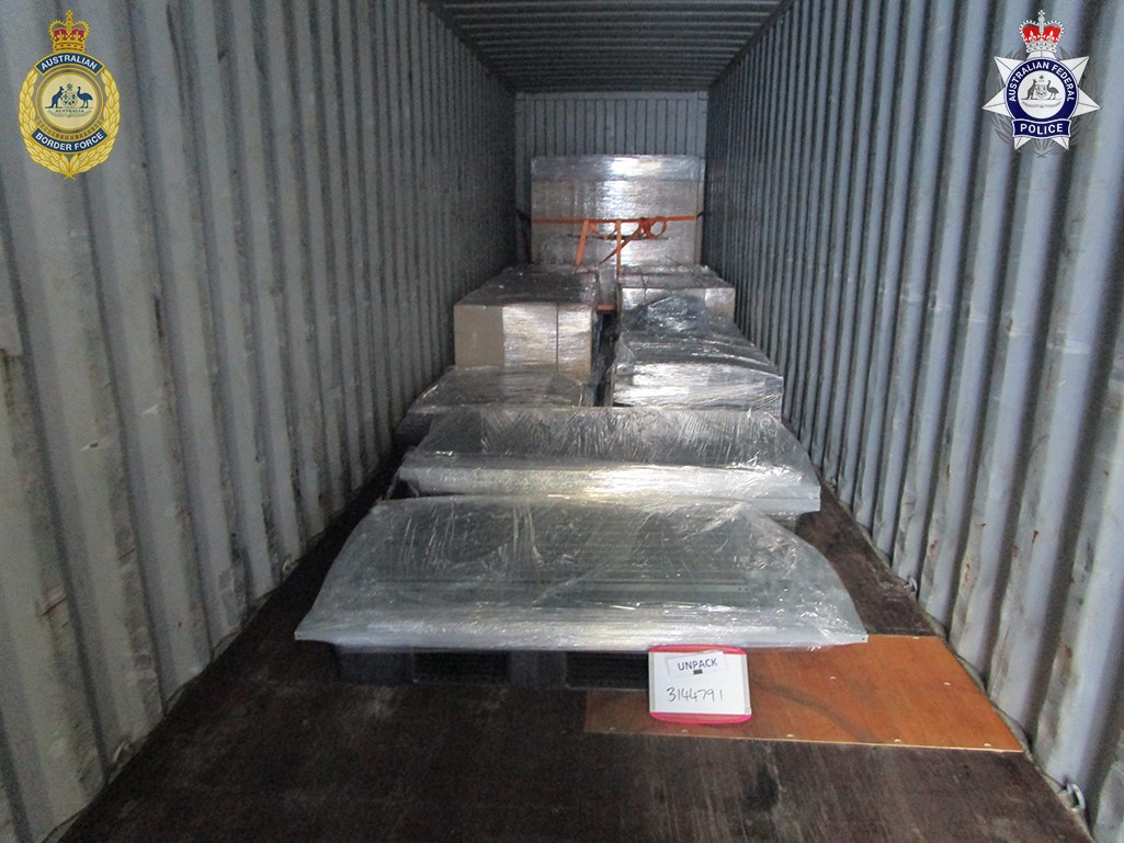 Large items wrapped in plastic, inside a shipping container