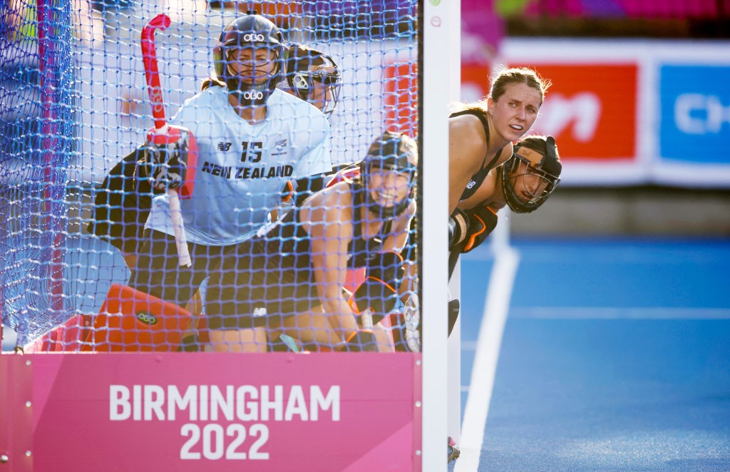 New Zealand players peer out from inside the goal