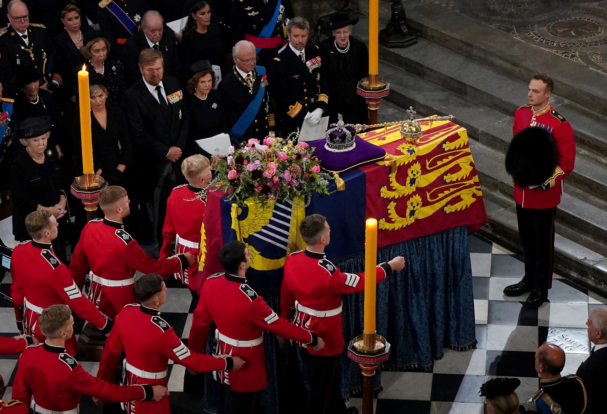 The Queens coffin lies in the middle of the room with men marching around it