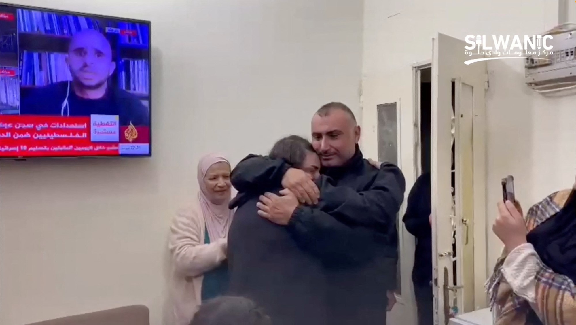 A woman being hugged by a man. 