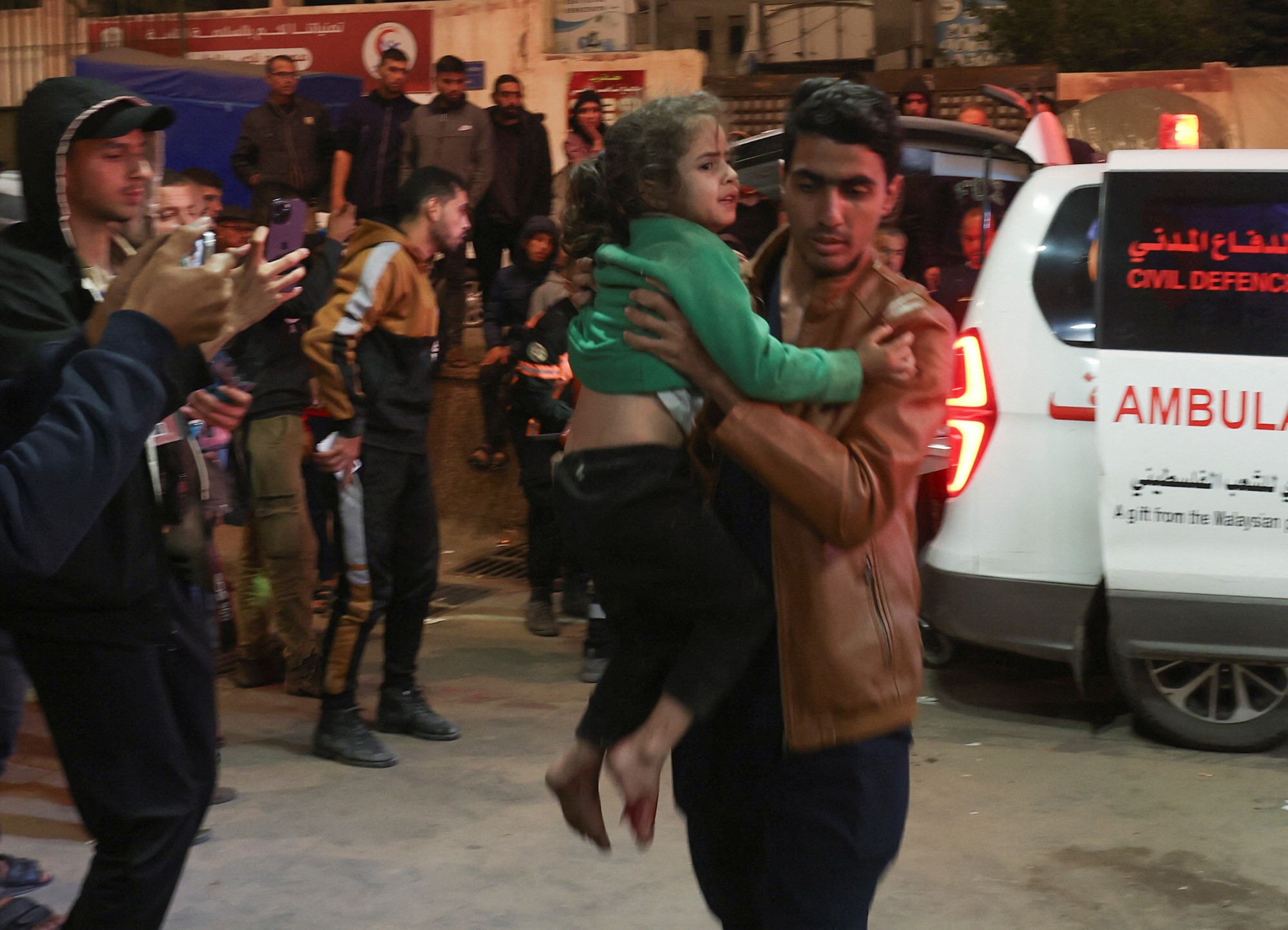 Man carries a young girl with green jumper. 