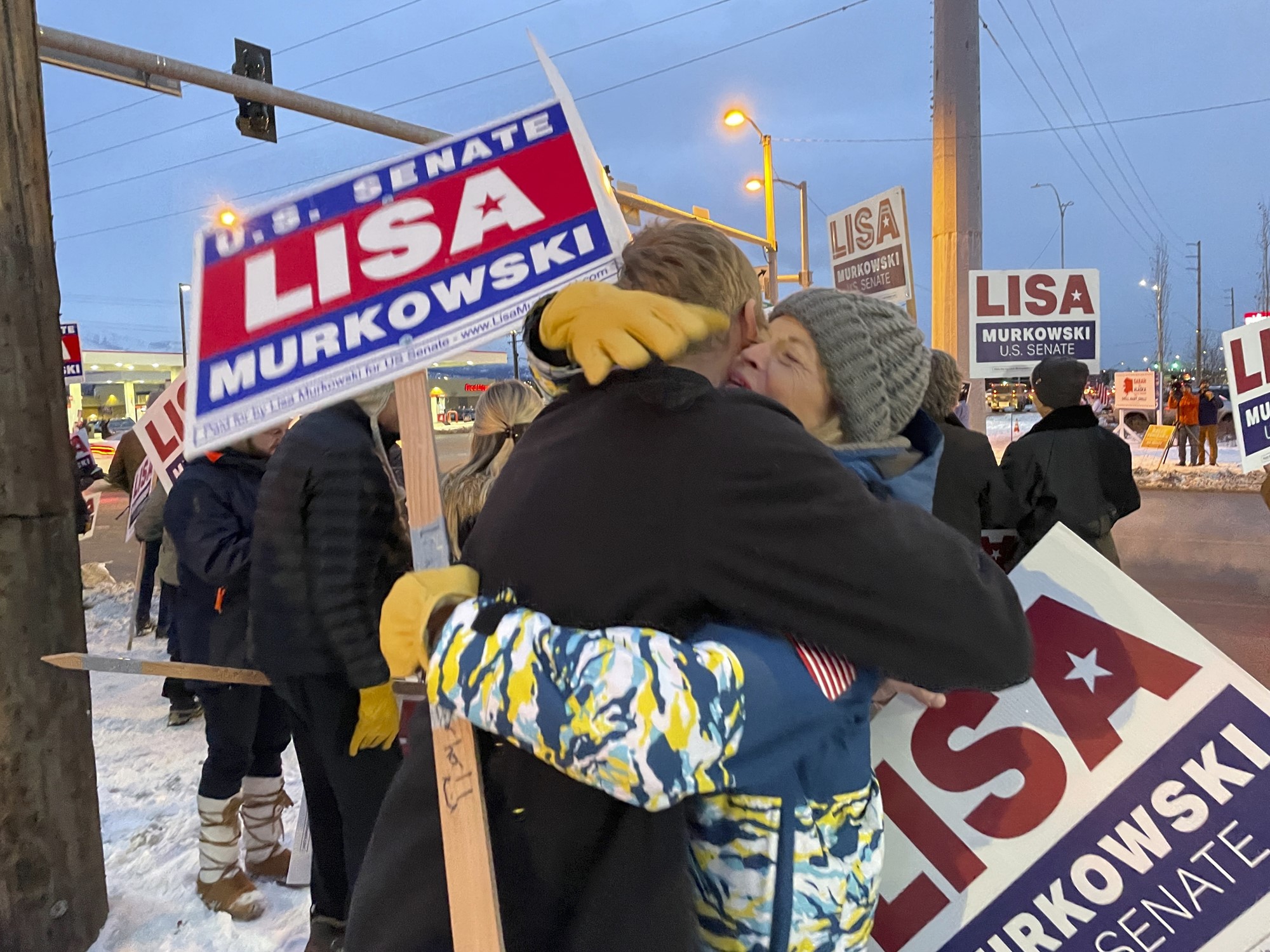 Lisa hugs her nephew while holding picket signs.