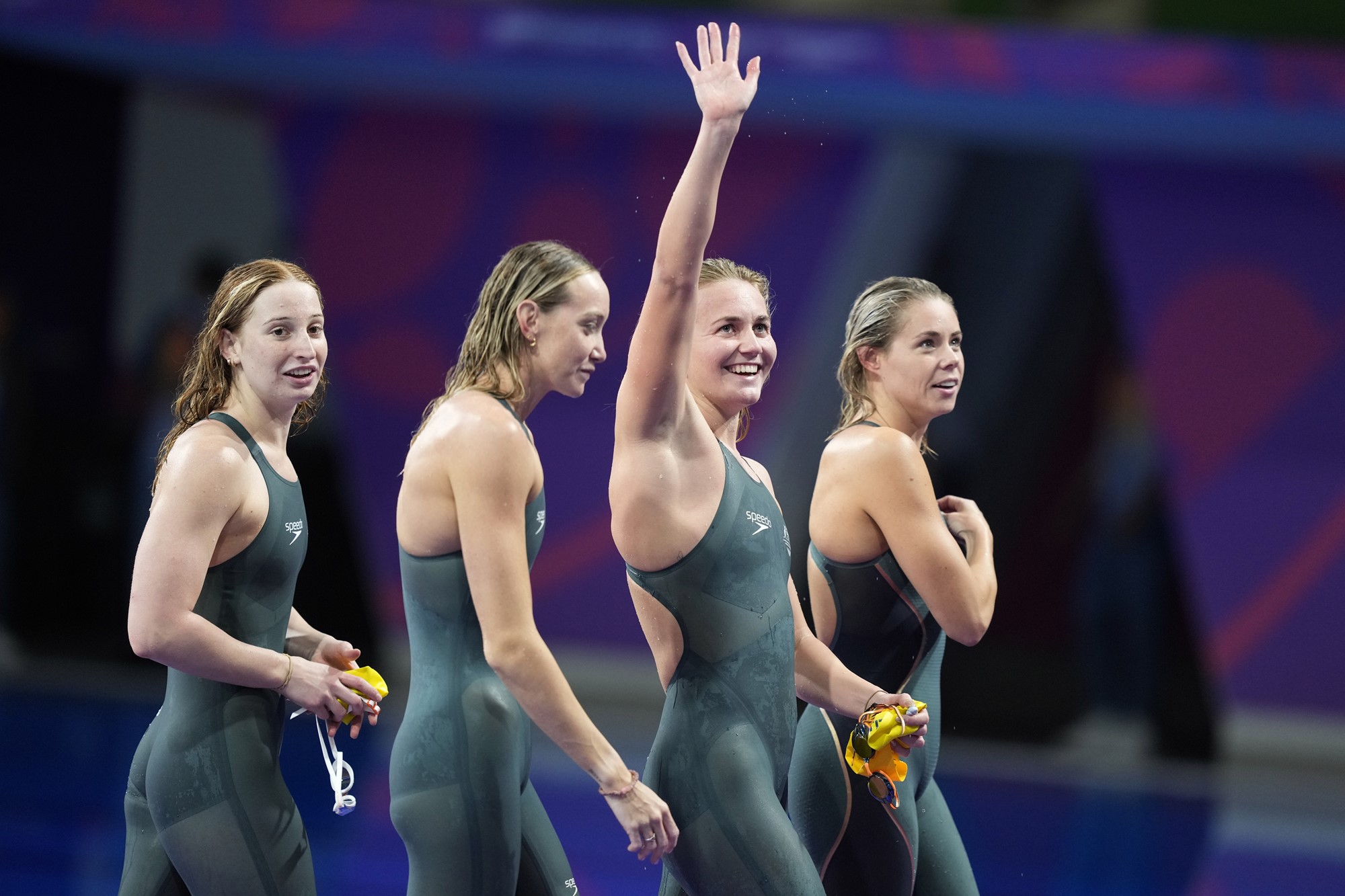 mollie o'callaghan, madi wilson, ariarne titmus and kiah melverton smile and walk away from the pool after breaking relay record