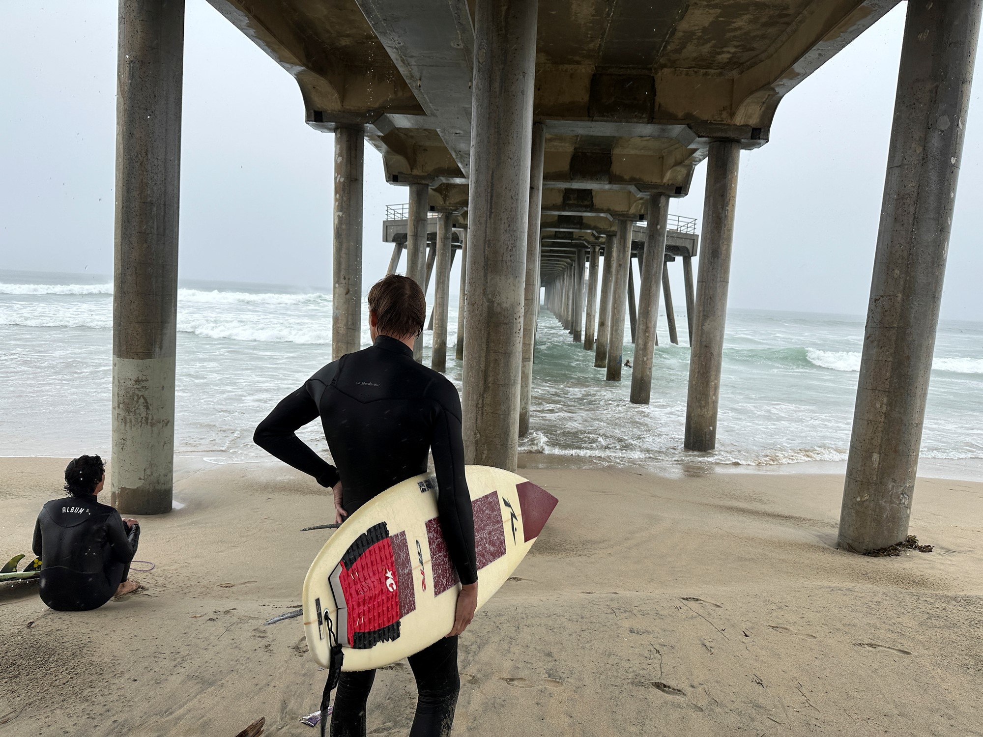 Huntington Beach surfers prepare to ride waves brought on by tropical storm Hilary at Huntington Beach