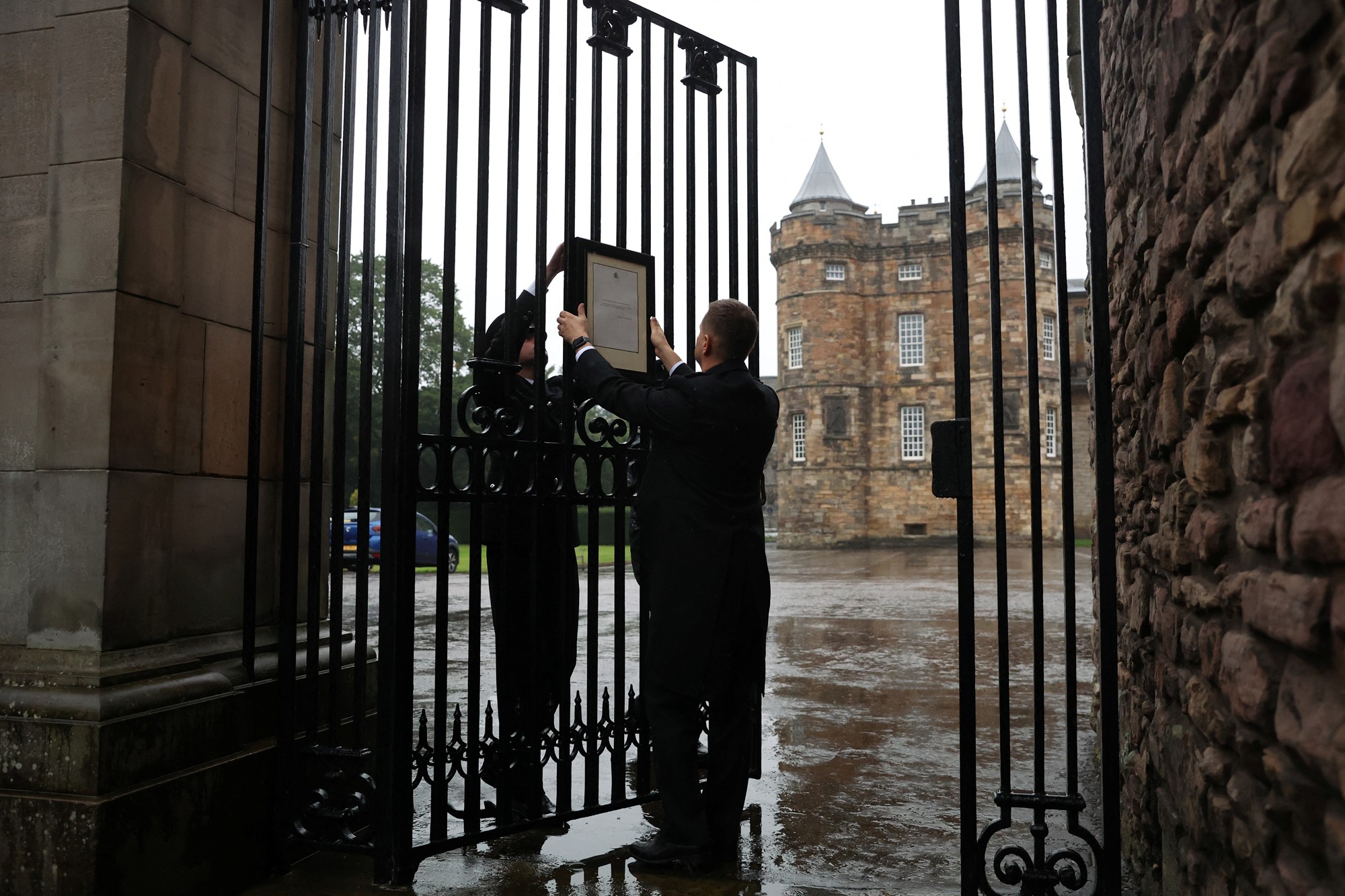 I cancelli del palazzo di Holyroodhouse sono stati fotografati mentre due uomini appesi ai cancelli annunciavano la morte della regina.