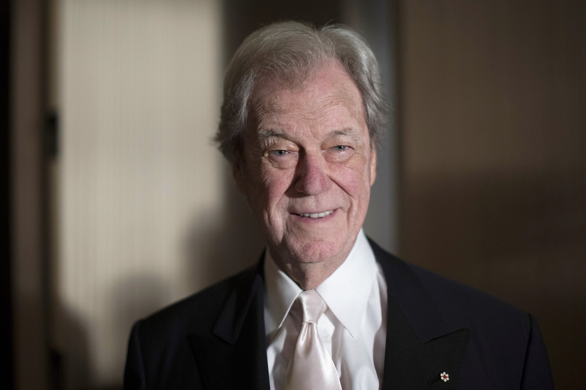 Gordon Pinsent, a senior white man, in a suit with a black jacket and white shirt and tie. 
