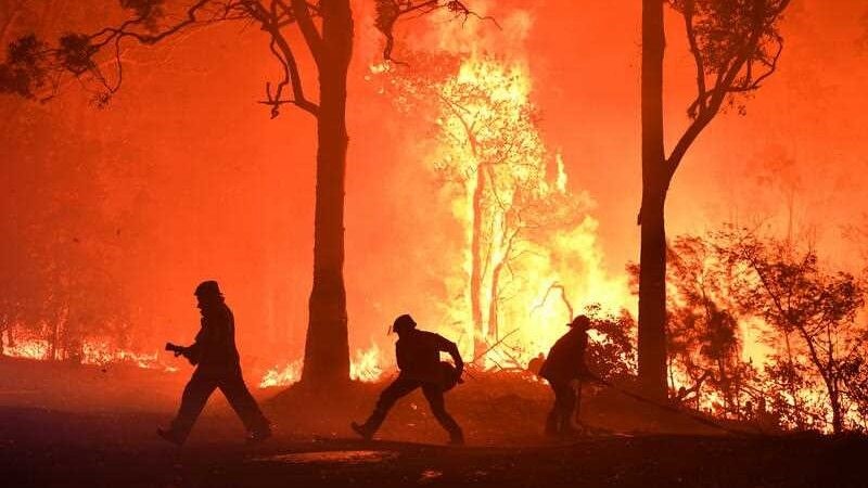 Three firefighters attempt to put out a huge blaze.