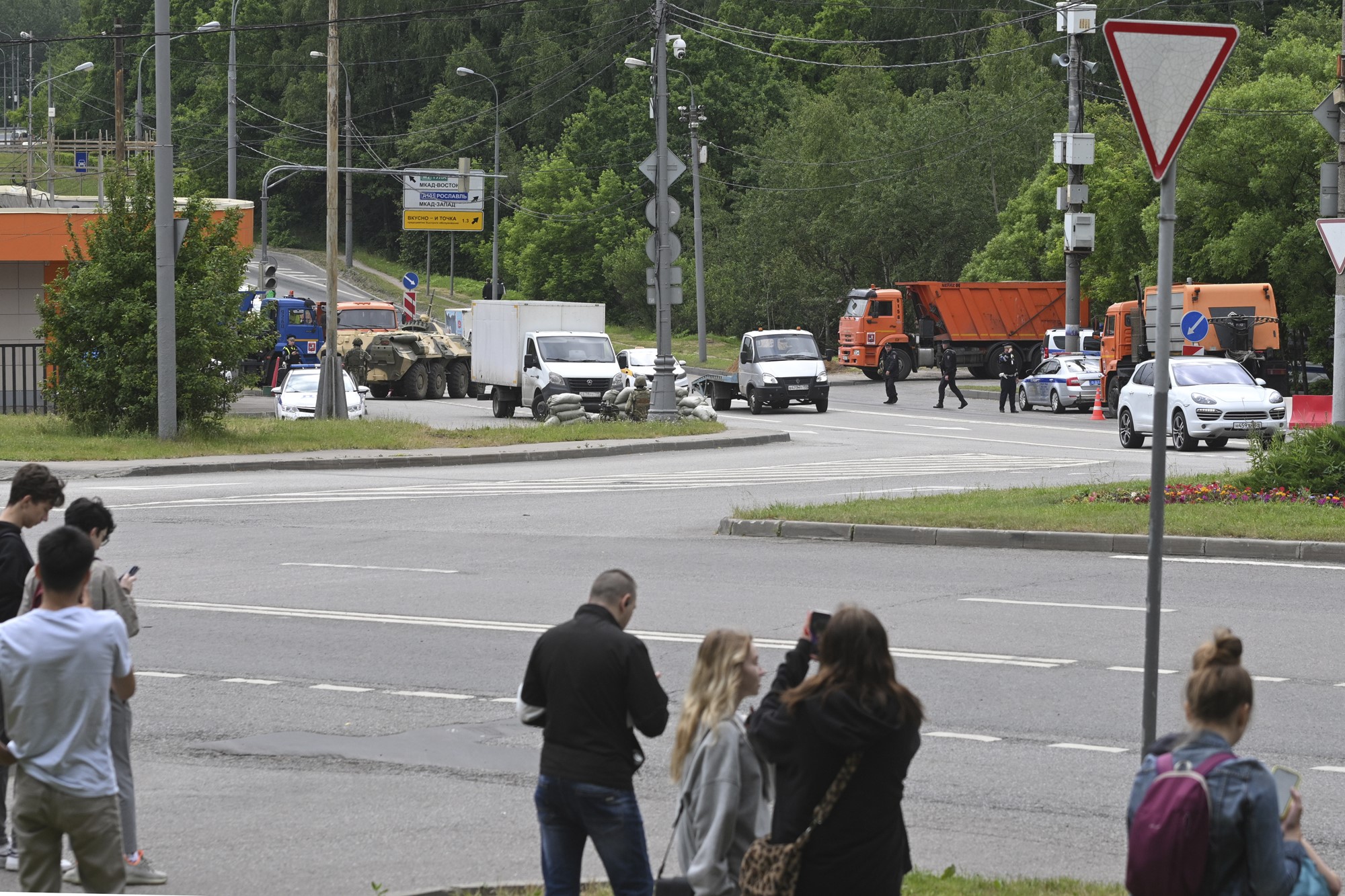 Civilians photograph the roadblock, which is visible from a nearby intersection