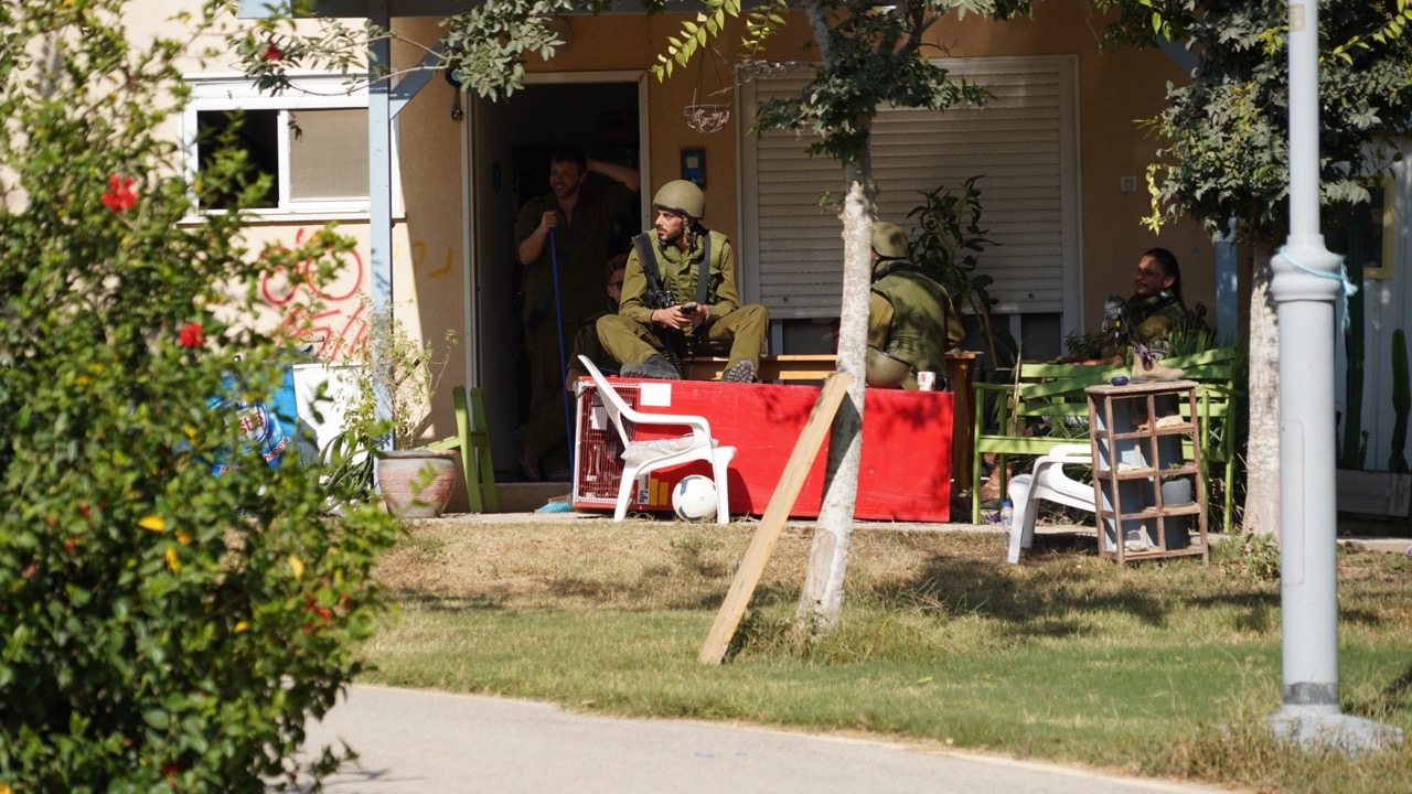 Soldiers sitting outside a home in military gear
