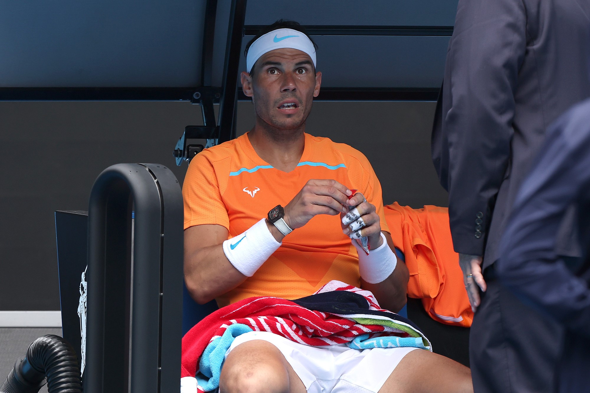 Rafael Nadal seated on Rod Laver Arena.