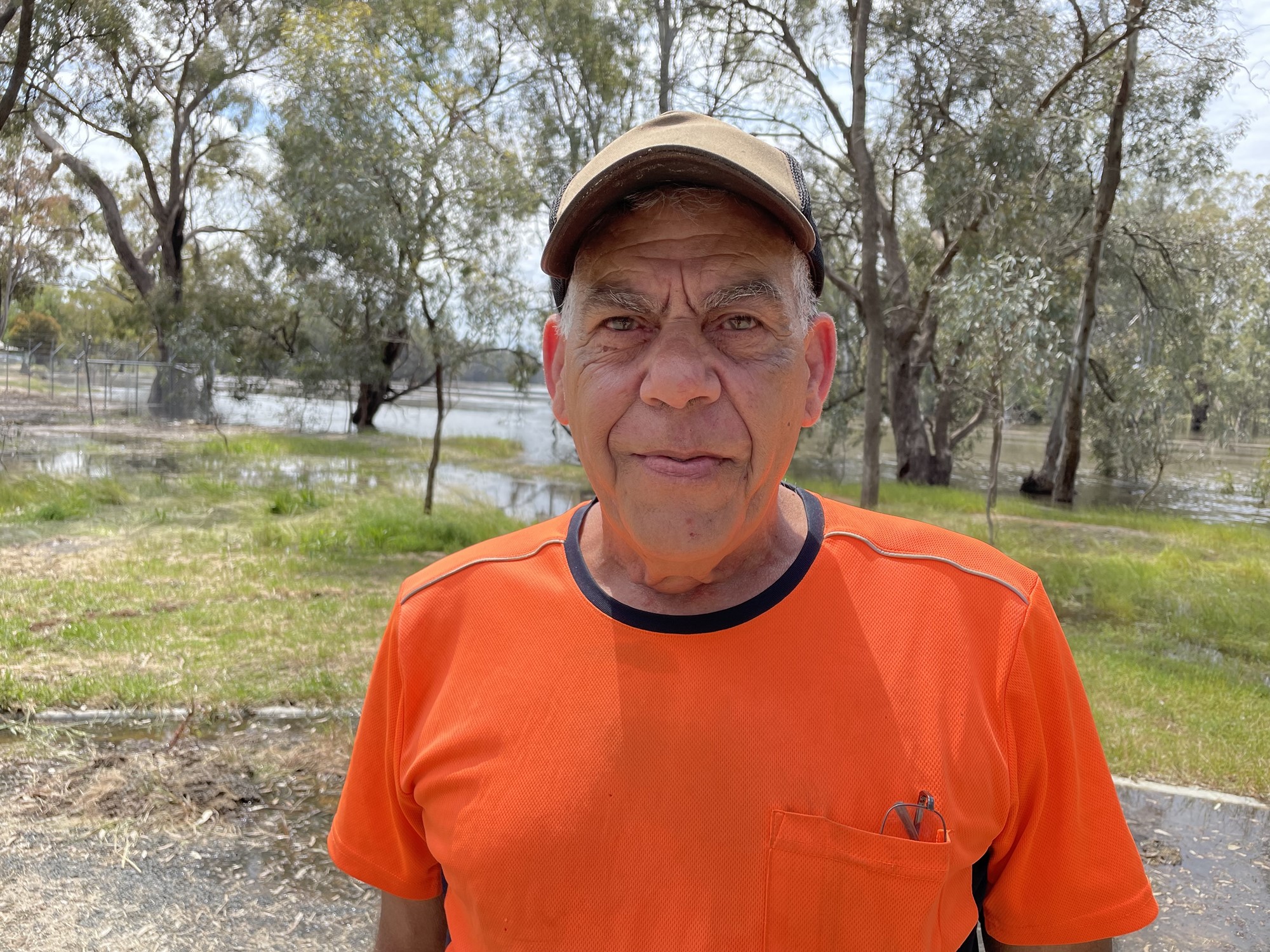 A man in front of a flooded bushland.