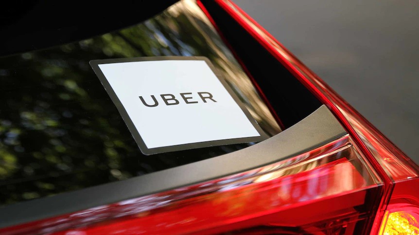 A close up of an Uber sticker on the back of a car windscreen