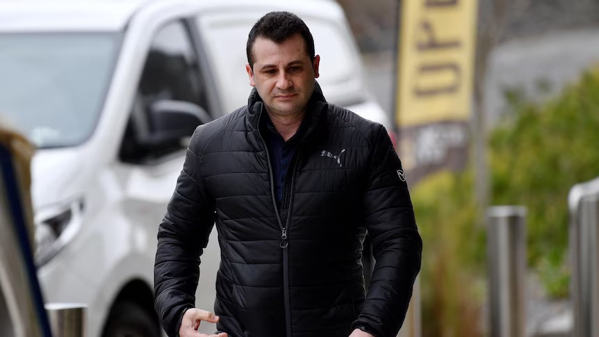 A man in a puffer jacket walking up a street