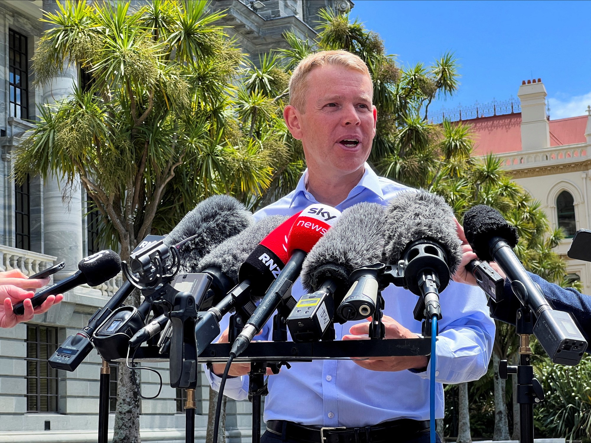 Chris Hipkins stands in front of several media microphones at a press conference.