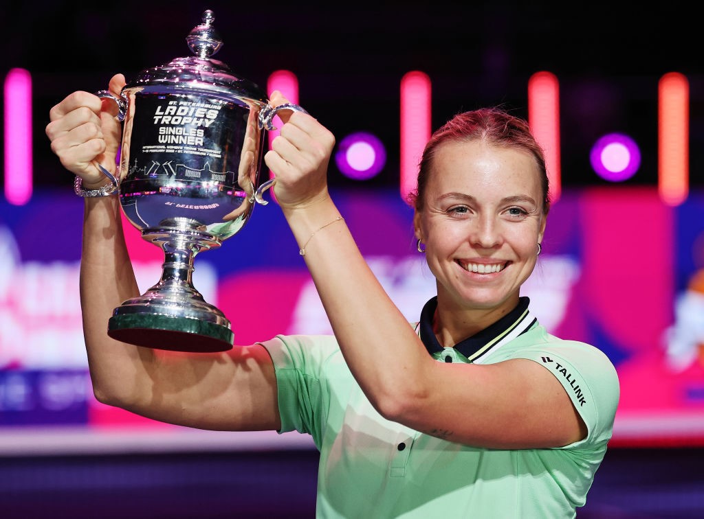 Anett Kontaveit holds a silver cup and smiles