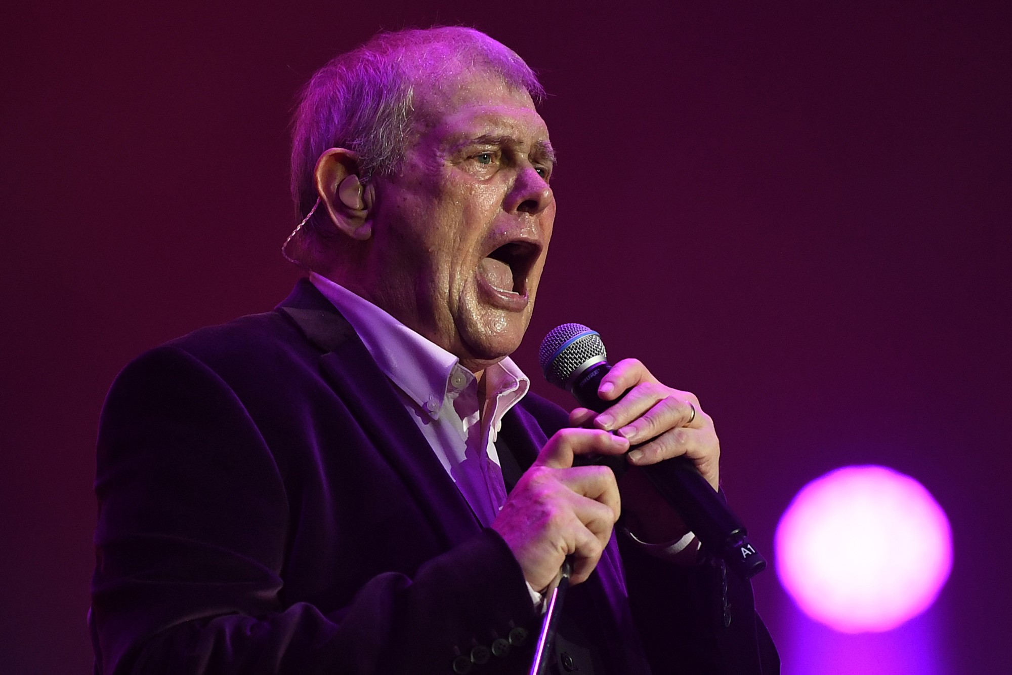 Singer John Farnham singing into a microphone