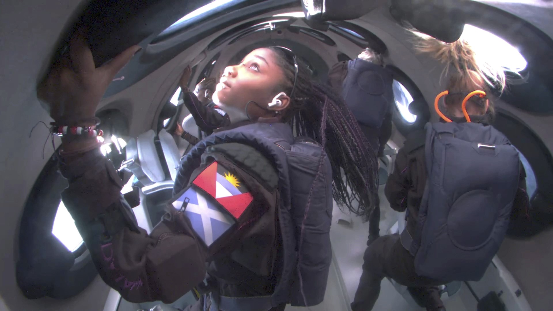 Anastatia looks out the window as she floats in the rocket cabin