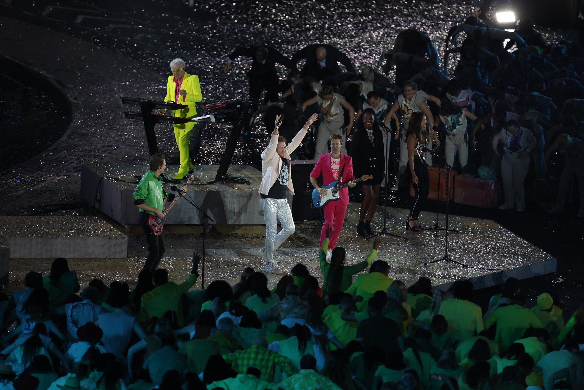 members of duran duran perform on stage in the middle of a stadium surrounded by people