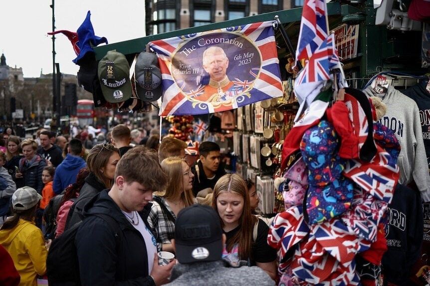 Crowds gather underneath a coronation flag.