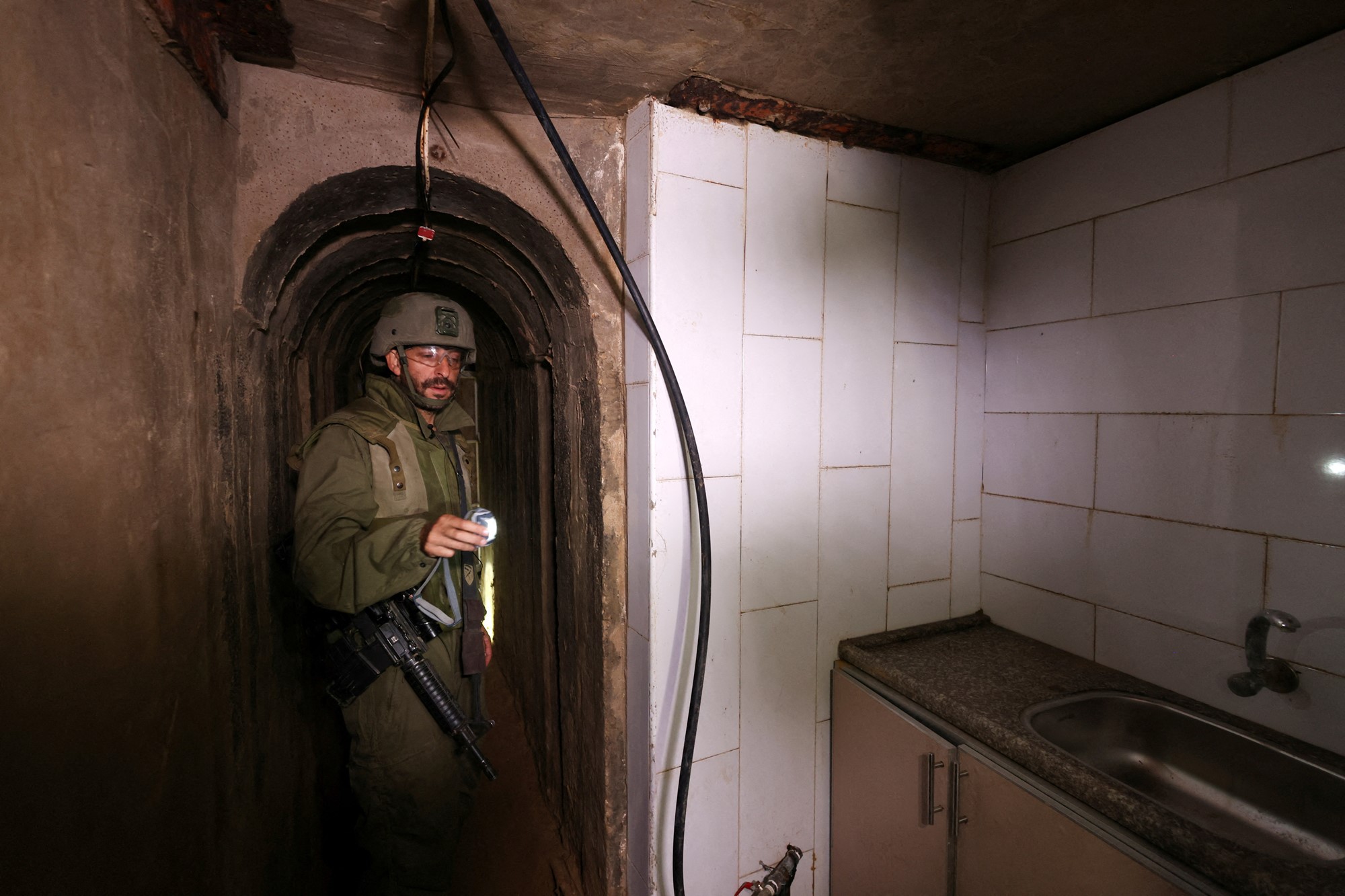 A soldier is pictured in a dark space with a kitchen sink on the right.