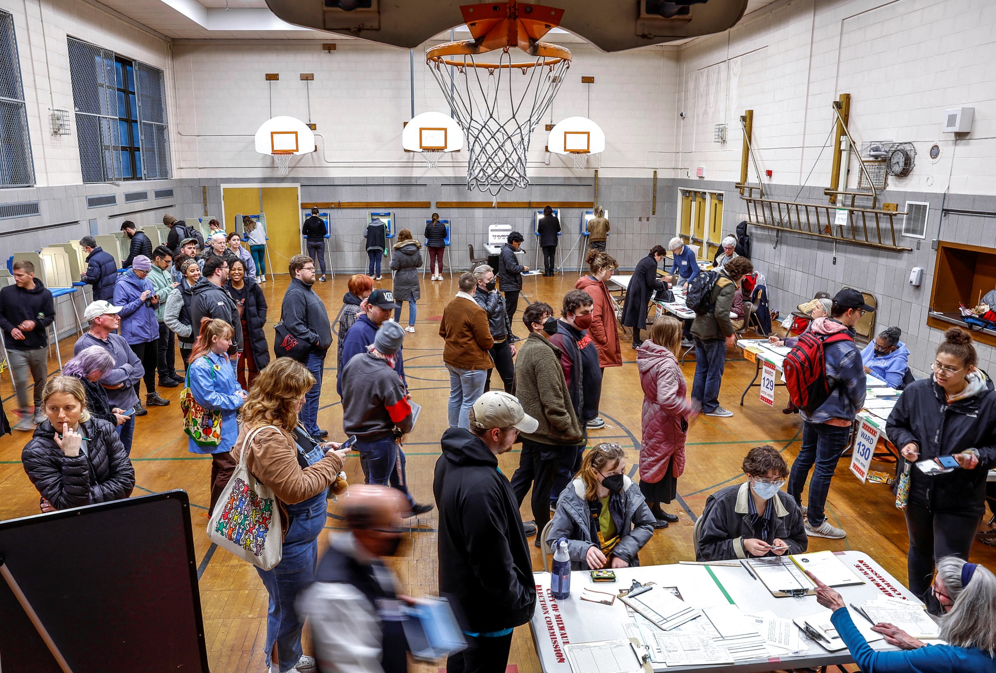 Voters gather in a school gym to cast their vote.