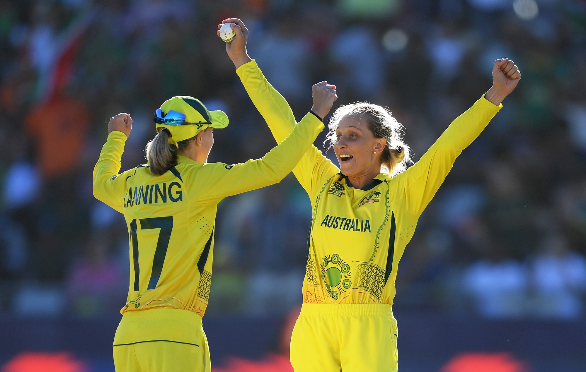 Australia bowler Ash Gardner holds the ball aloft as she celebrates with captain Meg Lanning.