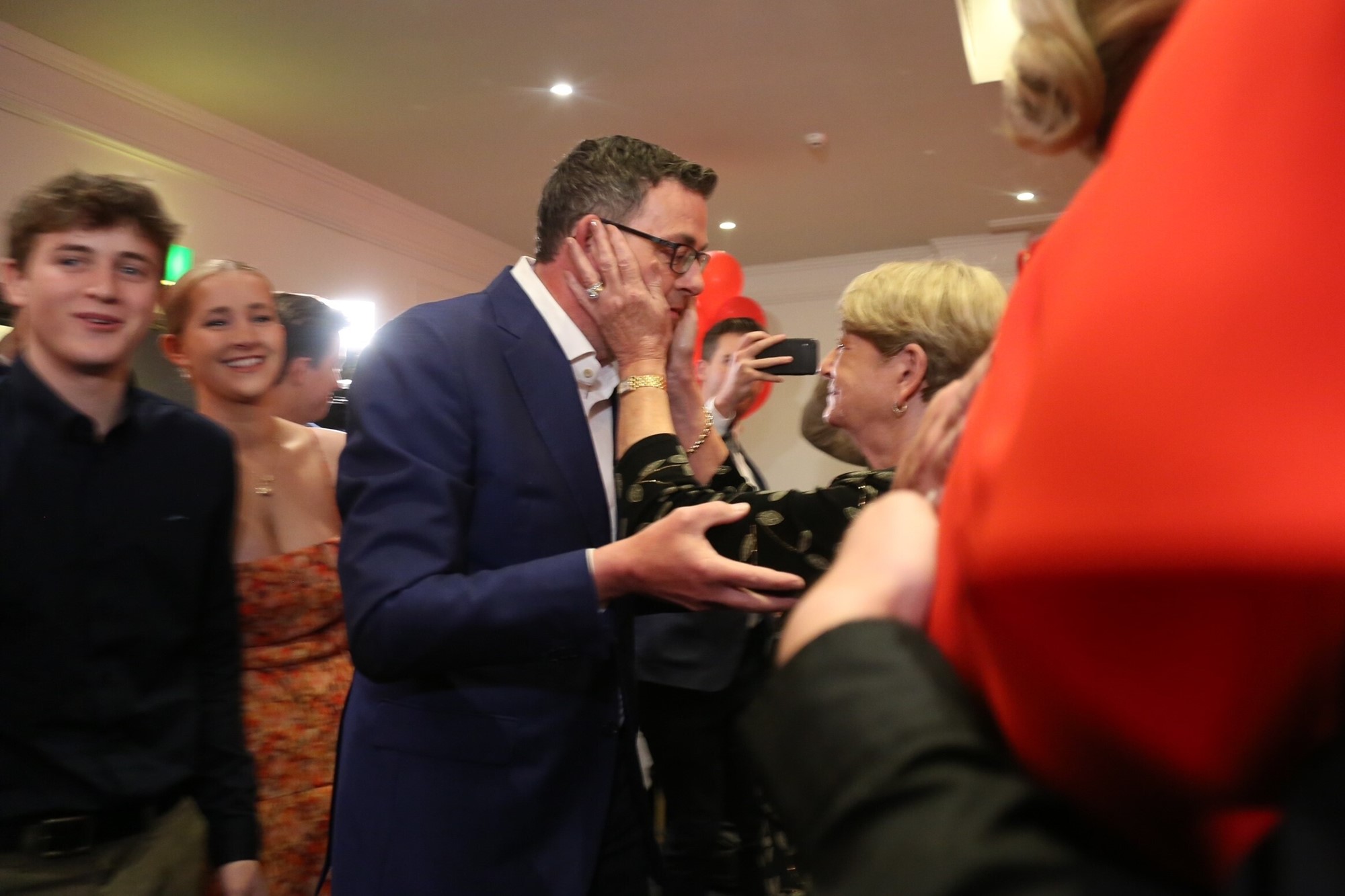 A relative holds Daniel Andrews's face in her hands.