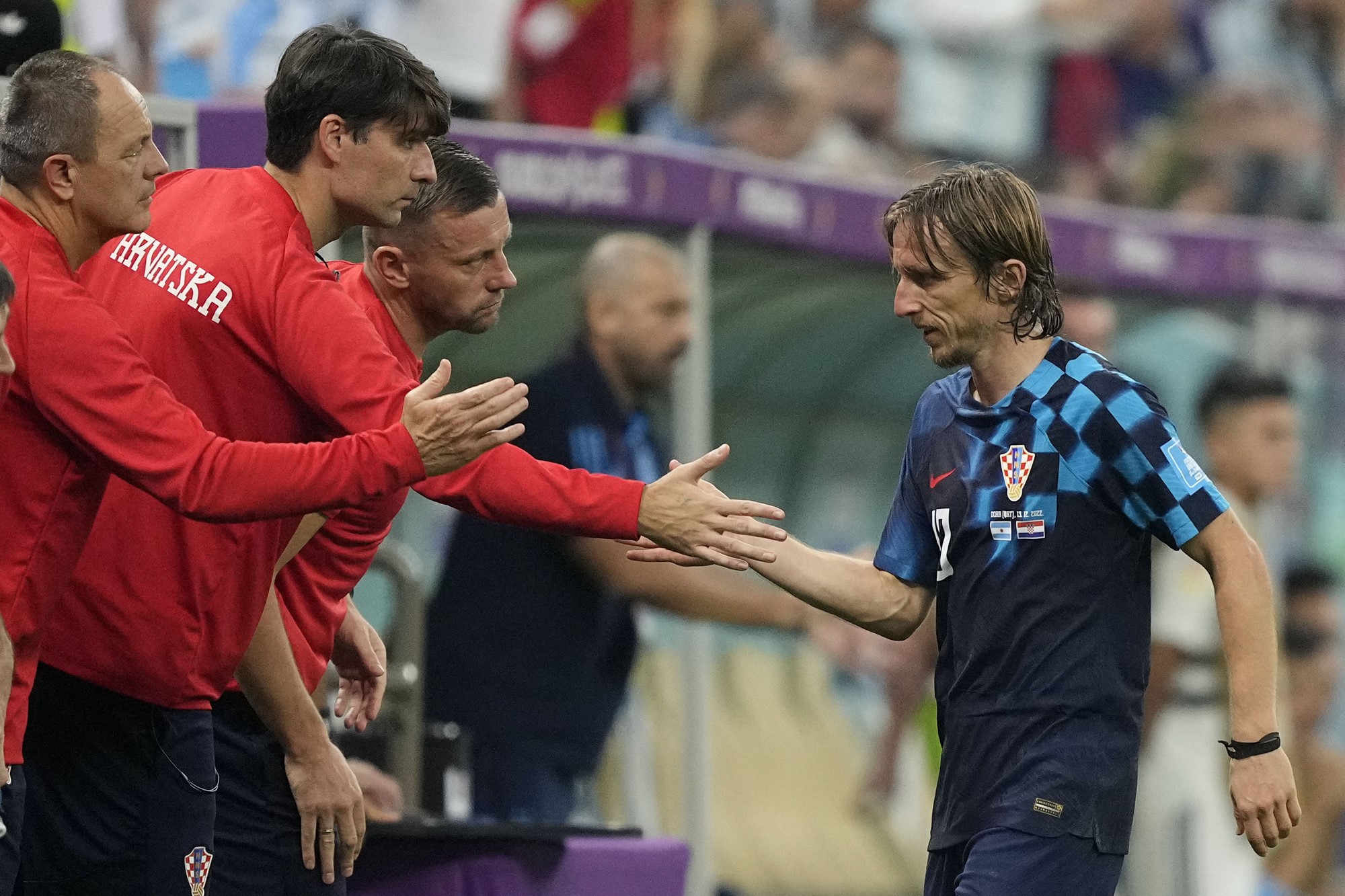 Luka Modric high-fives Croatia teammates as he leaves the field in the FIFA World Cup semifinal against Argentina.