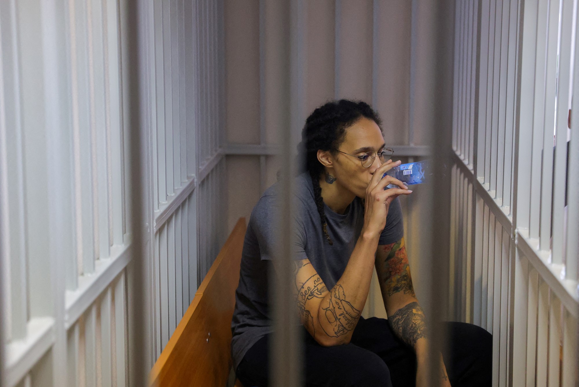 U.S. basketball player Brittney Griner, who was detained at Moscow's Sheremetyevo airport and later charged with illegal possession of cannabis, drinks water inside a defendants' cage after the court's verdict