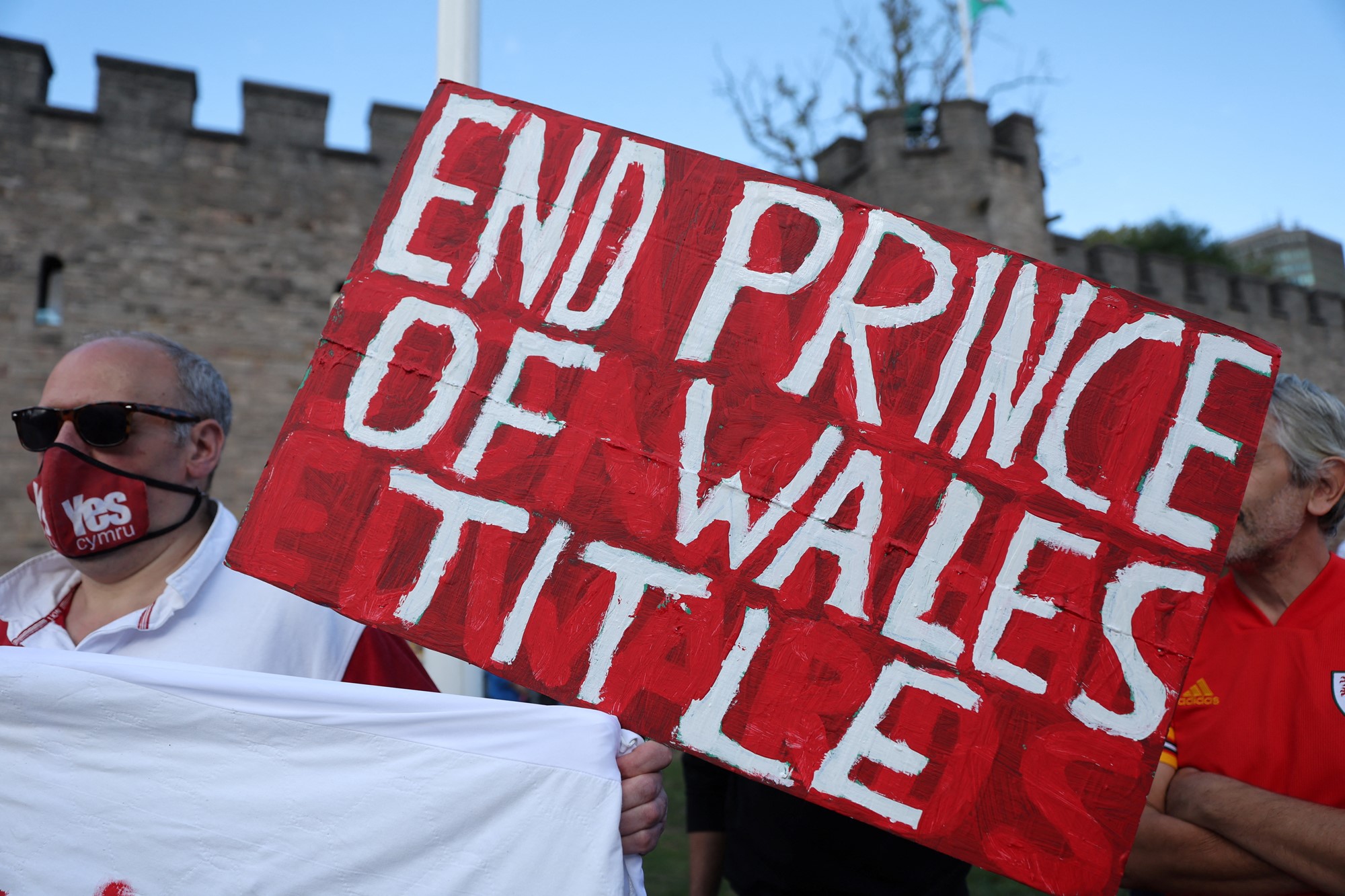 A man holds a sign that reads "End Prince of Wales Title"