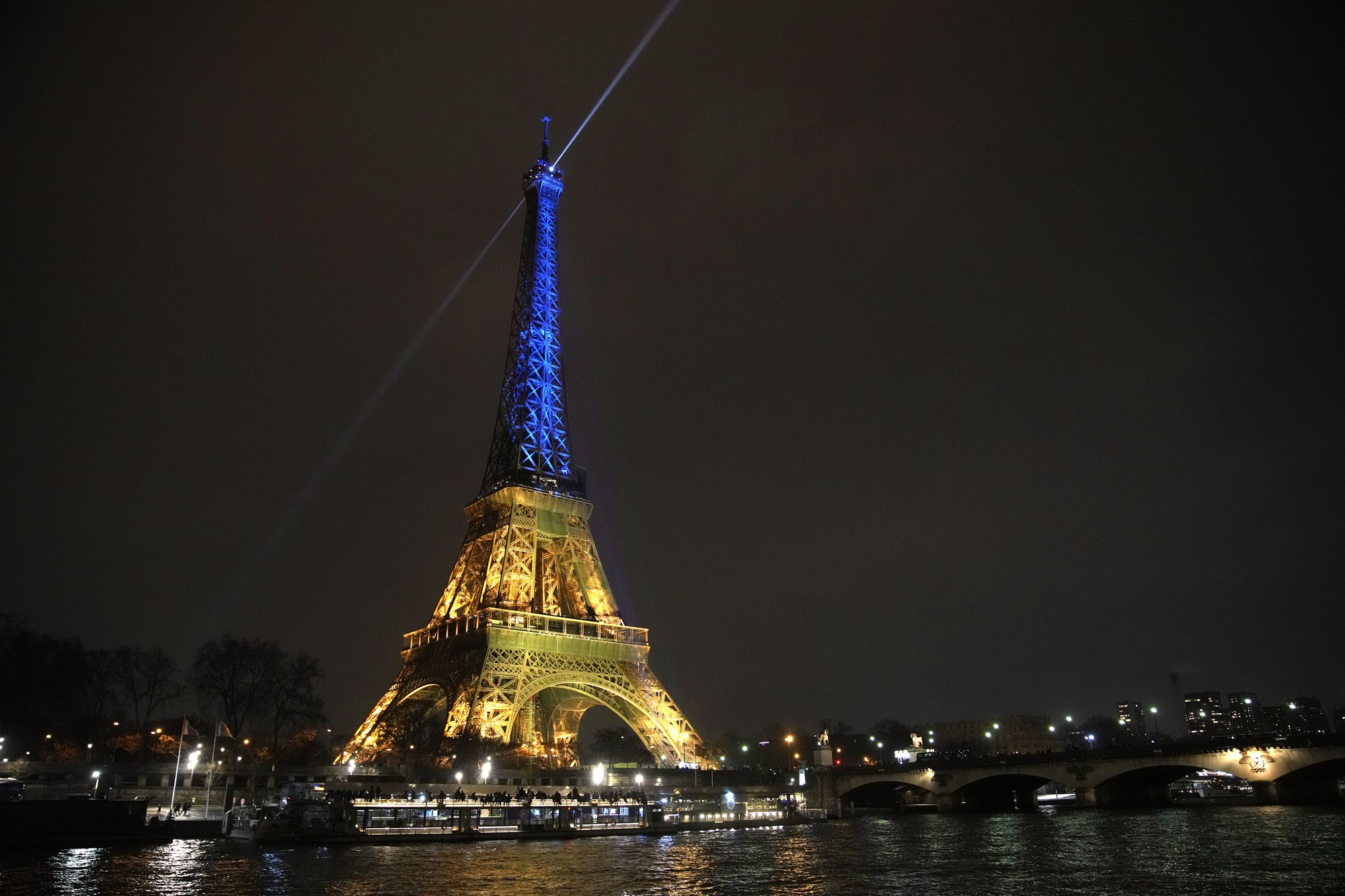 The Eiffel Tower lit up in blye and yellow.