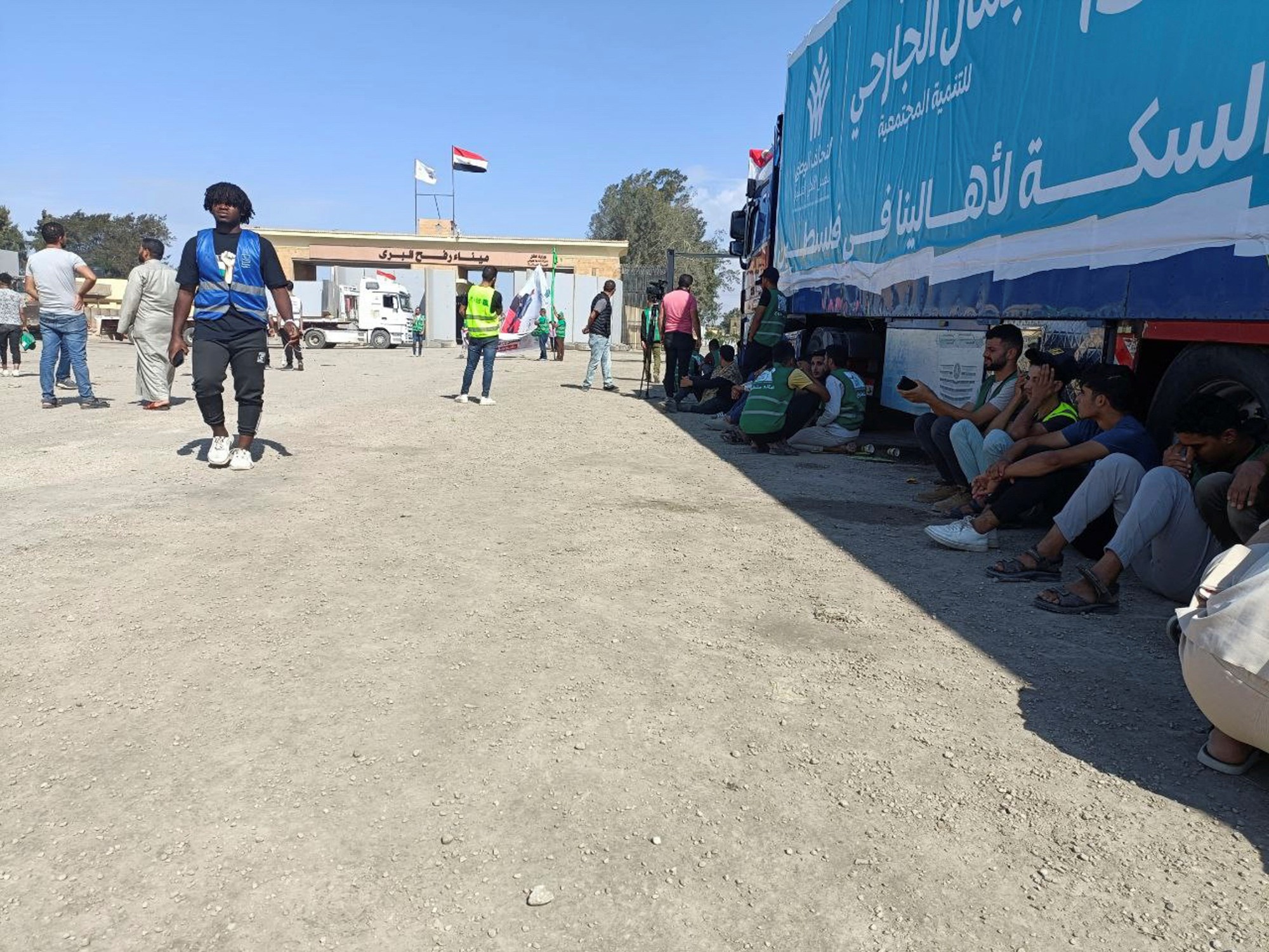 People sitting next to a truck at a checkpoint.