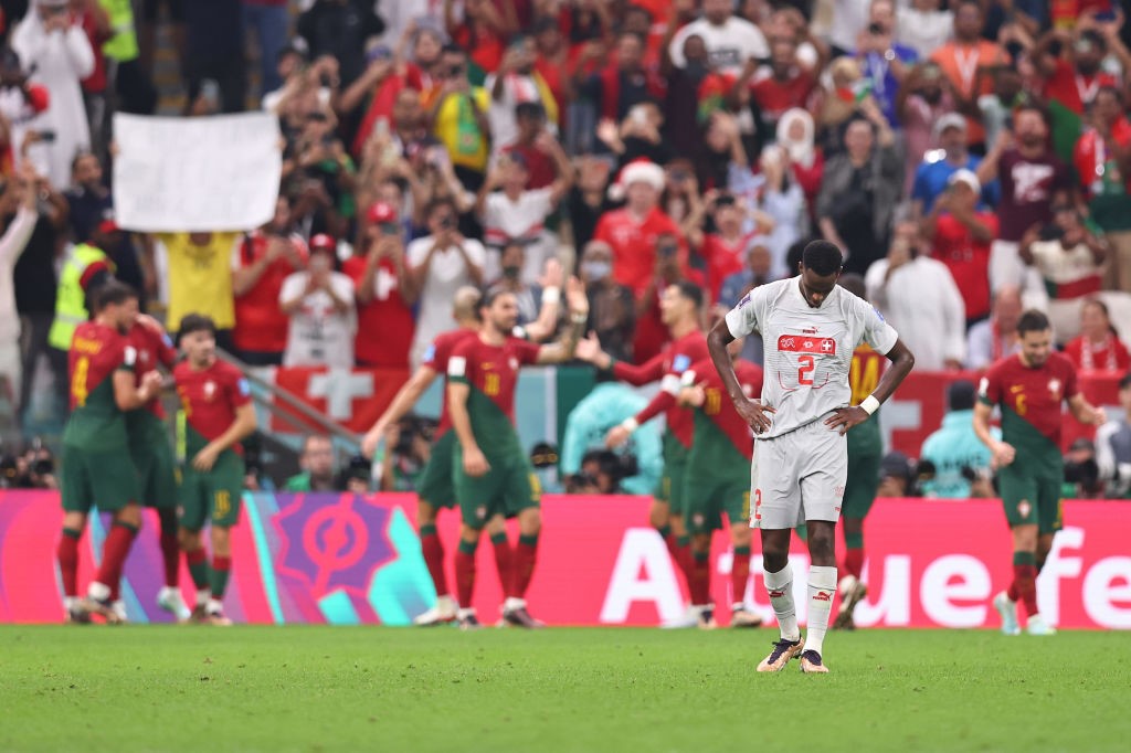 Switzerland's Edimilson Fernandes walks away as Portugal celebrates at the Qatar World Cup.