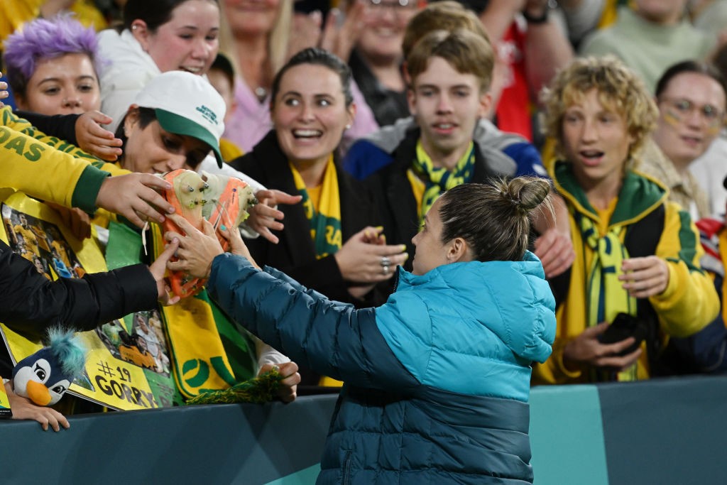 Katrina Gorry gives her boots to fans at the Women's World Cup.