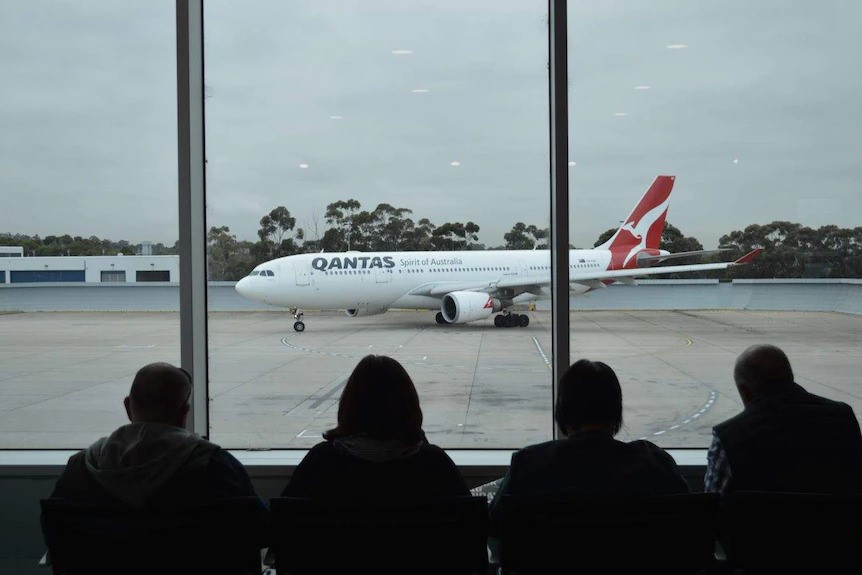 A Qantas plane sits on the tarmac.